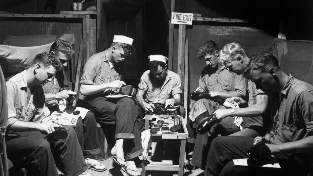 group of sailors shining shoes in tent