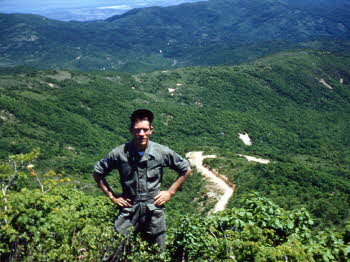 BerBert Crowson posing with his back to green mountains