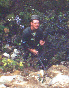 Charles Albright with a rifle in a deep side of mountain