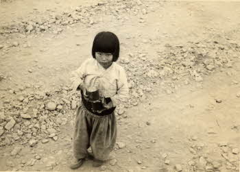 A Korean child holding cans