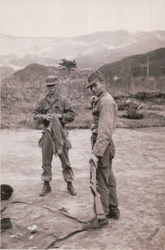 Two soldiers Cleaning a Rifle