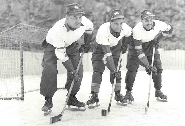 three soliders on ice with hockey sticks
