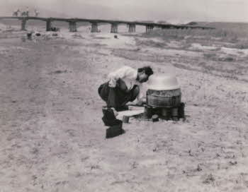 A Korean woman boiling water near bridge