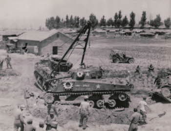 Two tanks and soldiers working on them