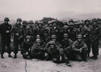Soldiers wearing helmets pose for a photograph