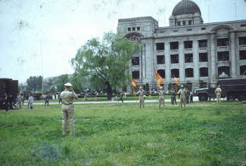 Soldiers holding flags in front of the Capitol building in Seoul