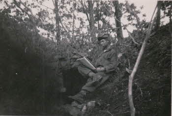 A soldier reading newspapers at dented ground***