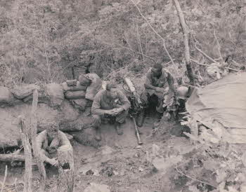 Back to the MLR near Kumhwa, North Korea after being in reserve at Hwachon reservoir. (from left to right) SGT. Carl, cook of sault Ste. Marie, Michigan / SGT. Harry Stewart of Harlan county, Kentucky / Crider (killed in motor accident November or December). Sitting on top of dead bodies buried in June.