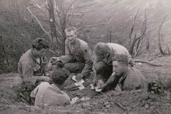 Gambling playing black jack, SGT. John Berns, center with cigarette, SGT. Harry Stewart with cigarette at right