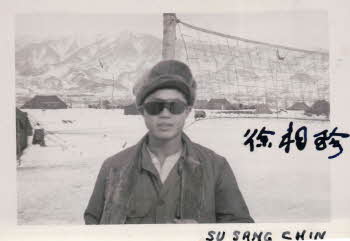 Standing by volleyball net, wearing pile cap, Chin is wearing sunglasses. 