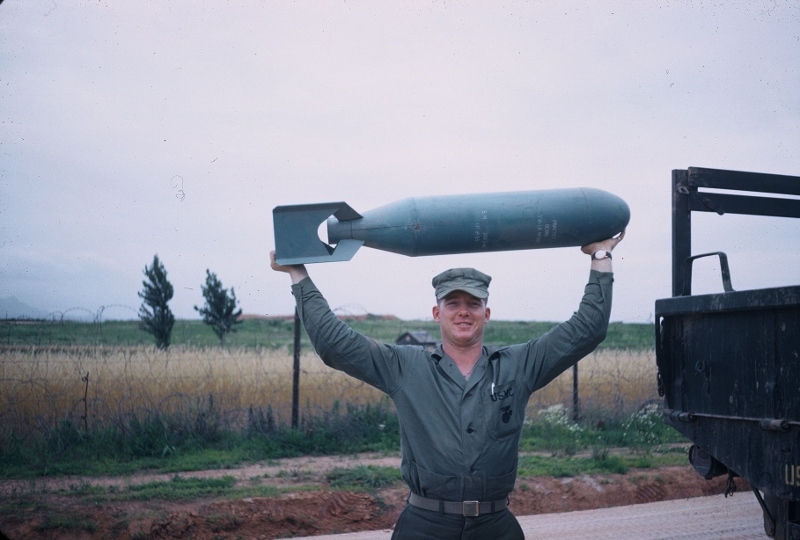 A strong marine holding up a torpedo. Taken in 1953.