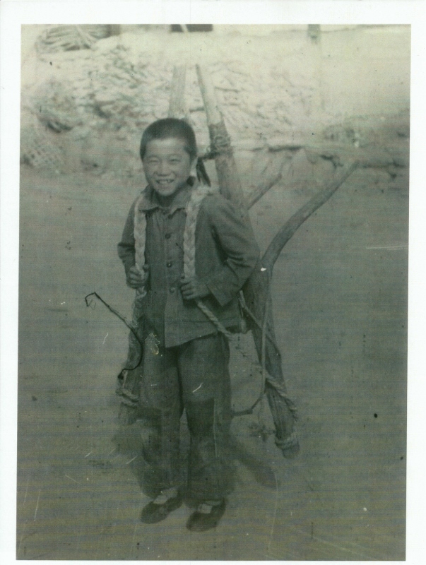 A boy with a typical carrying device called an A-Frame for its shape. Taken at Kwan Di Ri in 1953.