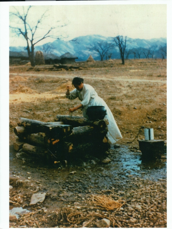 A picture of a woman getting water from the village well in 1954.