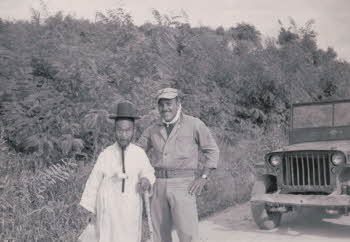 A Korean old man wearing traditional outfits and an US soldier