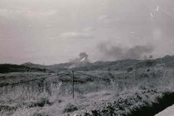 A distant view of mountain with smoke going up